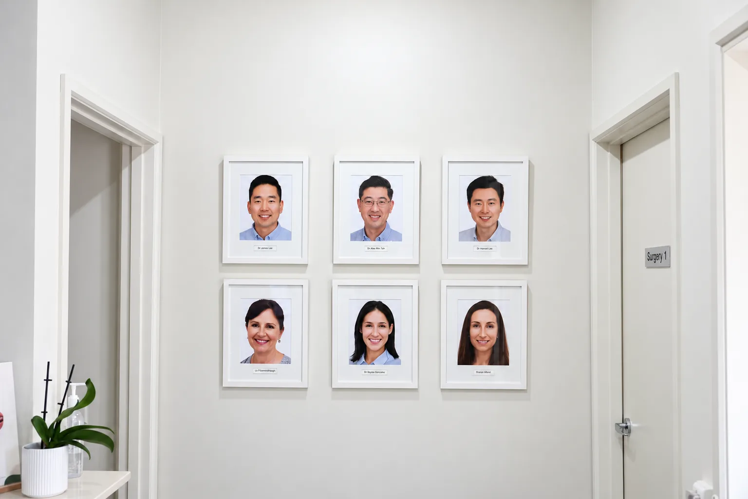 Six framed portraits of the Park Road Dental dentists and clinicians on the wall outside Surgery 1